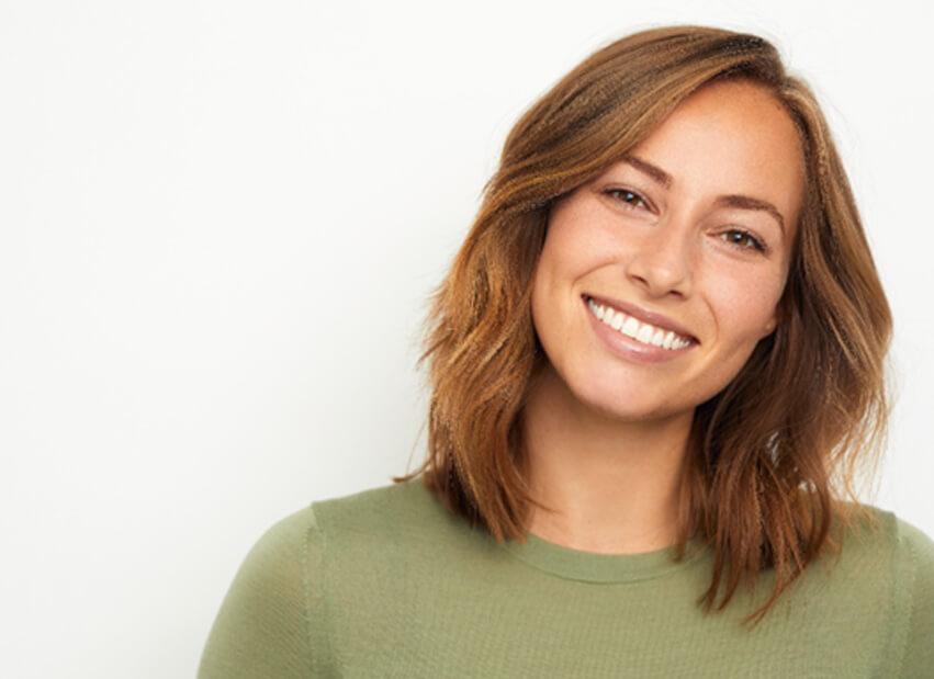 woman in green shirt with brown hair smiling