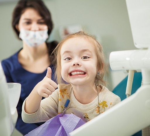 Girl giving a thumbs-up at the dentist