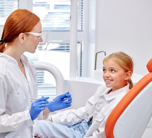 Young girl talking with her dentist