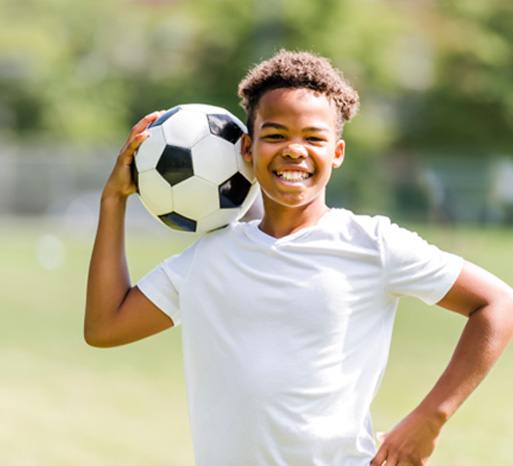 Boy proudly holding soccer ball