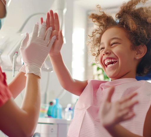 Child and dentist high-fiving each other