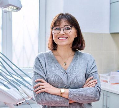 woman standing in dental office with arms folded